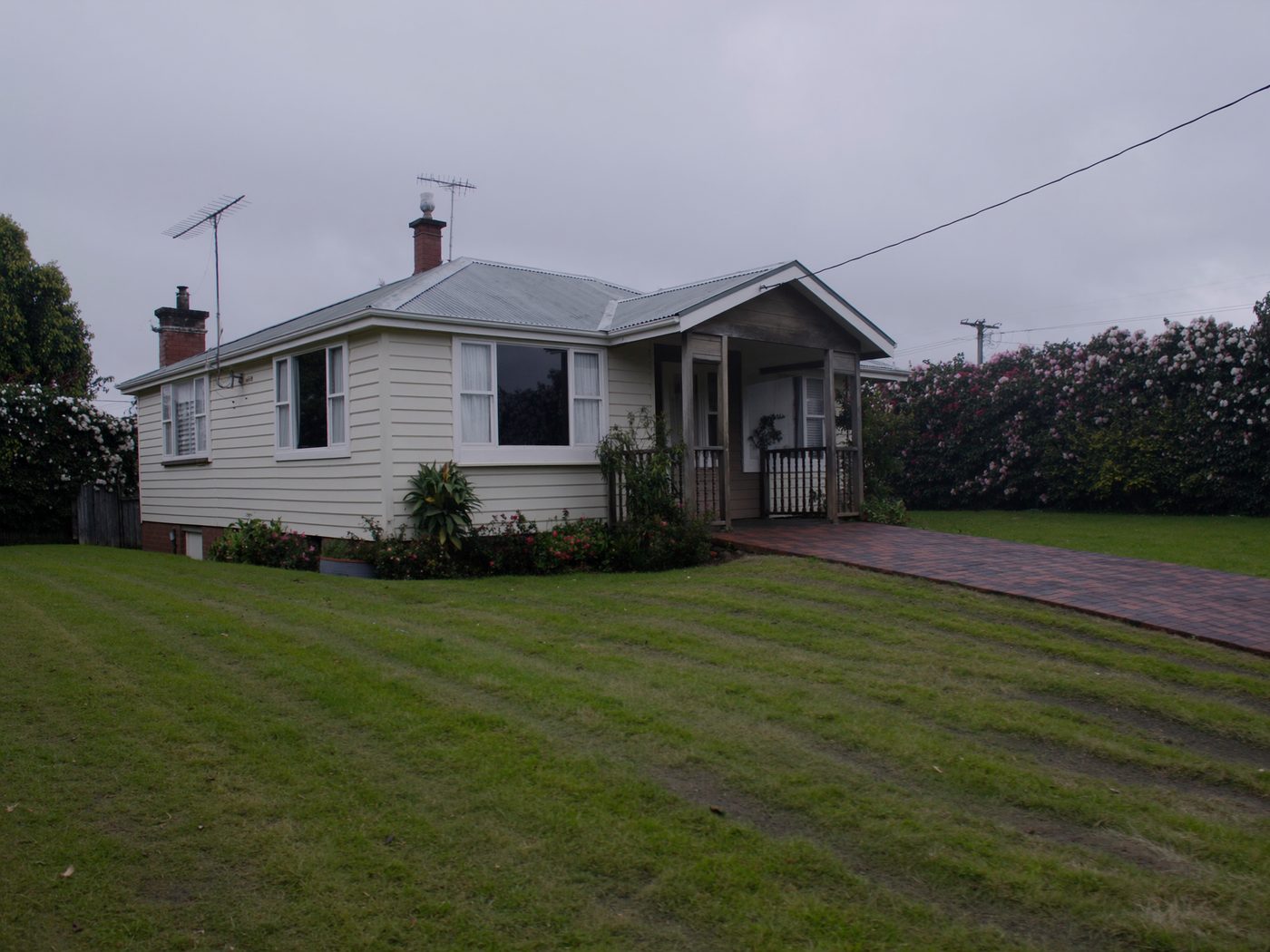 A weatherboard bungalow with a freshly mown front lawn
