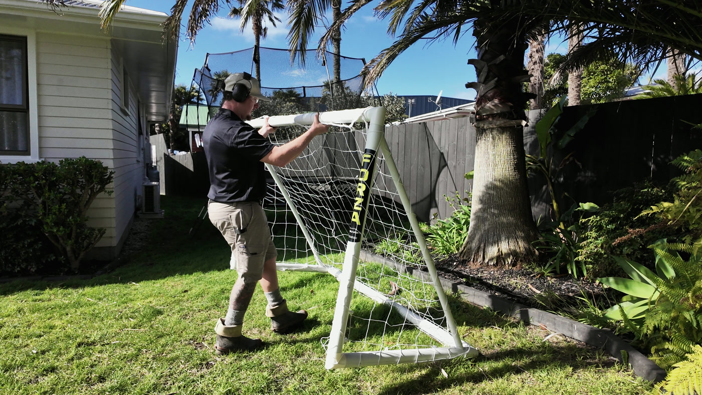 A Territory operator moving a football goal to care for the lawn beneath it