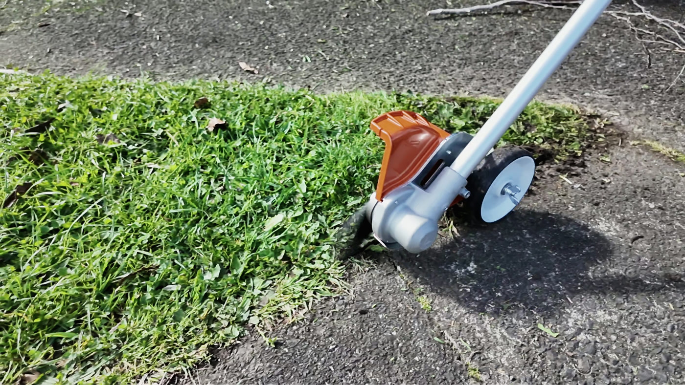 A close view of Territory working a lawn edge beside a path
